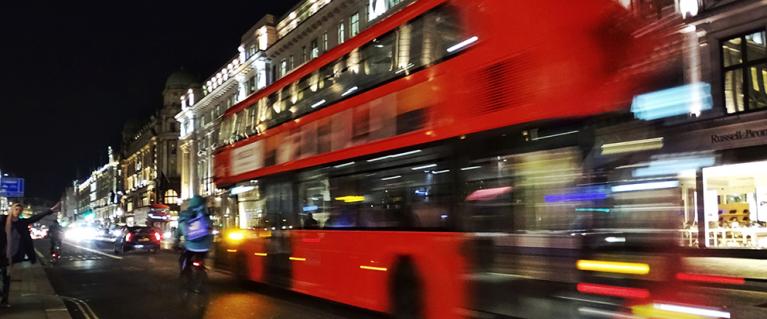 A bus on a London road at night
