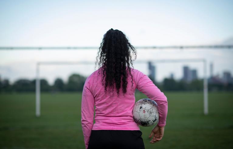 Female football player holding a ball