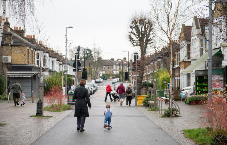 A parent and child walk down francis road in Leyton.