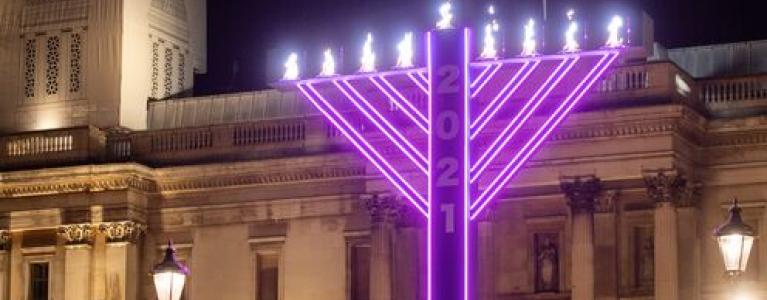 Giant menorah lit in purple colour for Chanukah close up