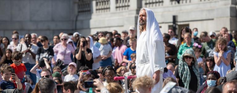 Actor portraying Jesus stands within a crowd on Trafalgar Square