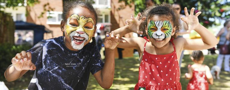 Two children wearing animal face painting