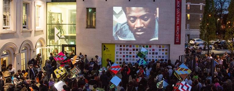 An event outside the Black Cultural Archives with big screen image of Darcus Howe