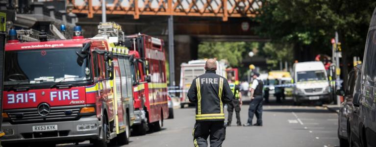 Fire trucks and firefighter outside of Grenfell Tower