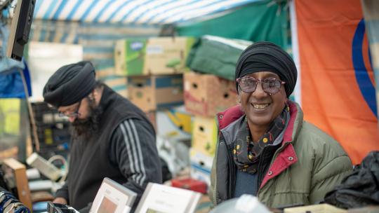 Market stall owner smiling at the camera