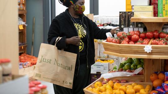 A member of public shopping in the fruit section of a grocery store.
