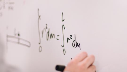 Person doing math on chalkboard