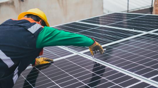 Engineer installing solar panels on a rooftop