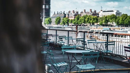 a table and chairs on a patio overlooking the river Thames