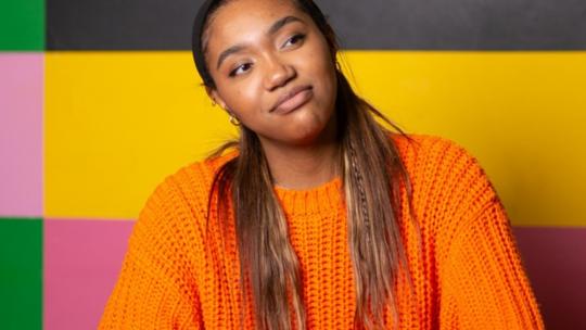 Young woman wearing an orange jumper
