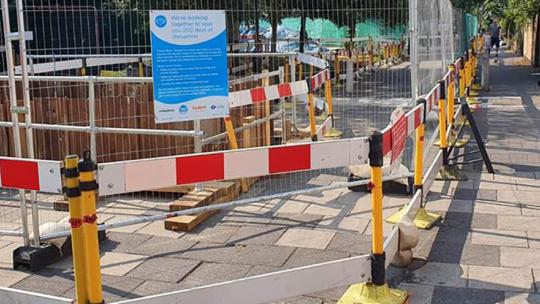 Road work confined by metallic fencing on a London road