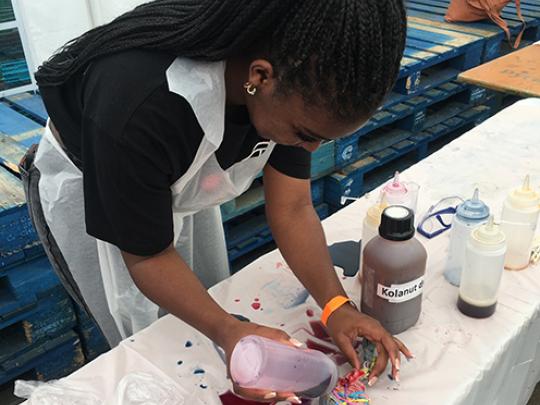 Teenage girl creates a Tye Dye t-shirt during a Festival of Ideas event
