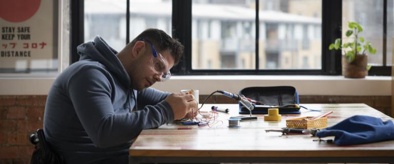 Man sitting at a desk and working on electrical systems