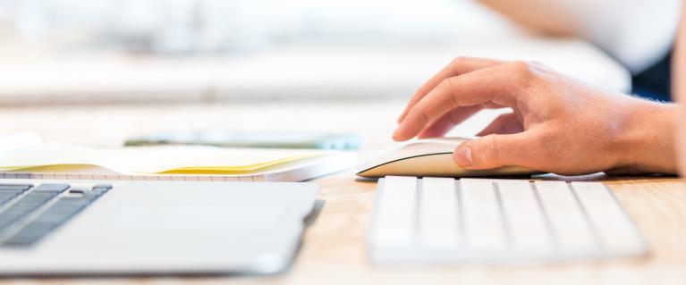 Close shot of hand of person using mouse and laptop