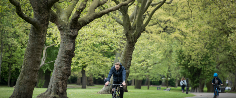 Person cycling through park