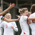 Players of England women's national football team hugging each other during a match
