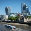 Image of London skyline with a boat in the foreground on the Thames river