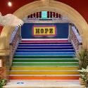 Rainbow coloured stairway with a sign at the top reading 'Hope'