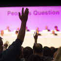 People from the audience raising their hands at People's Question Time