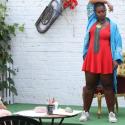 Woman stands on stage in a pub garden performing