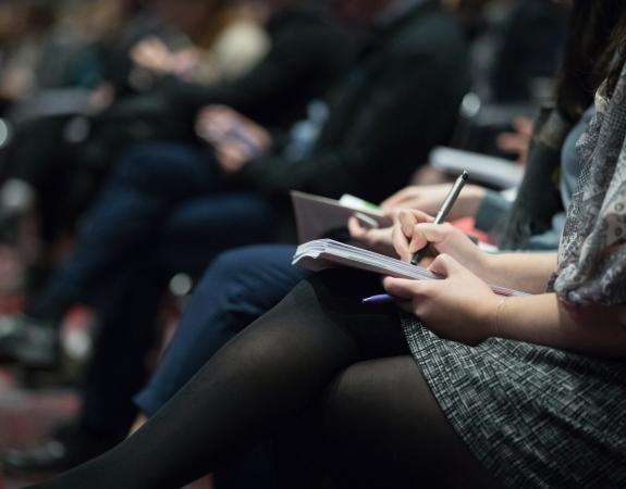Journalists taking notes at conference