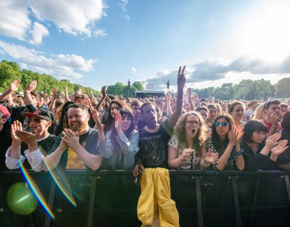 Festival goers cheering on a bright sunlight day in a London park