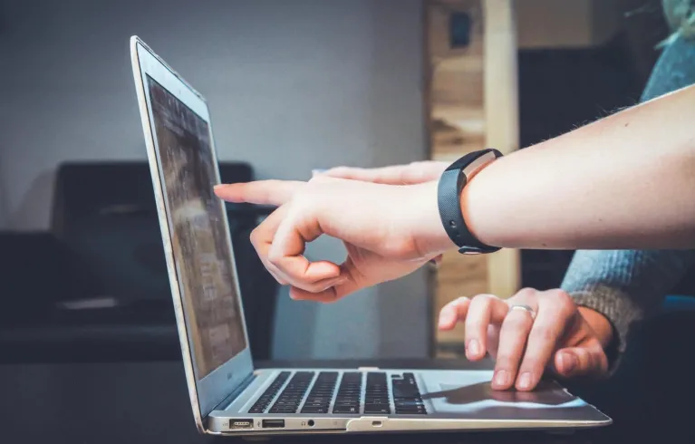 People pointing at laptop screen