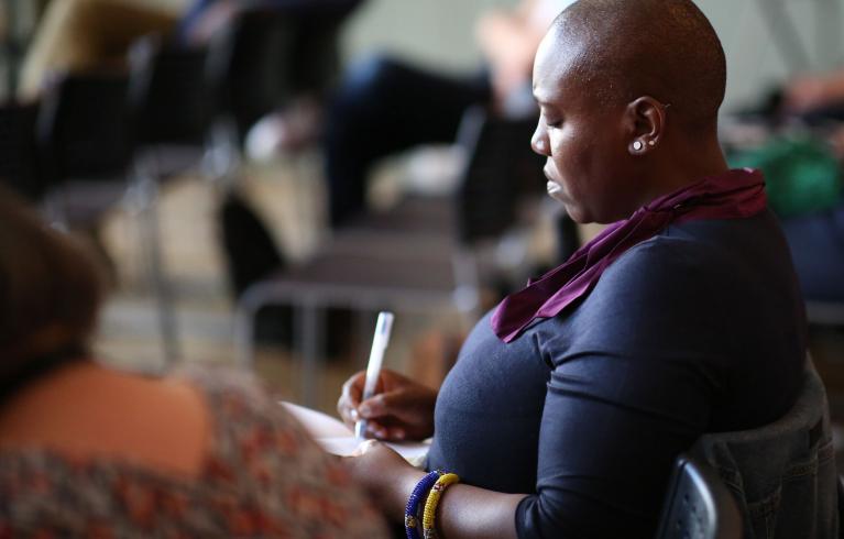 A woman taking notes at a Mayoral event