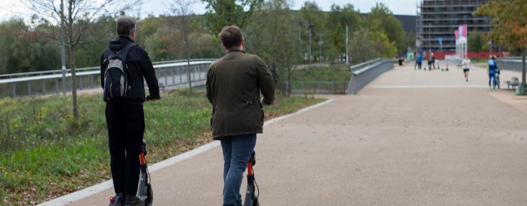 Two people riding e-scooters