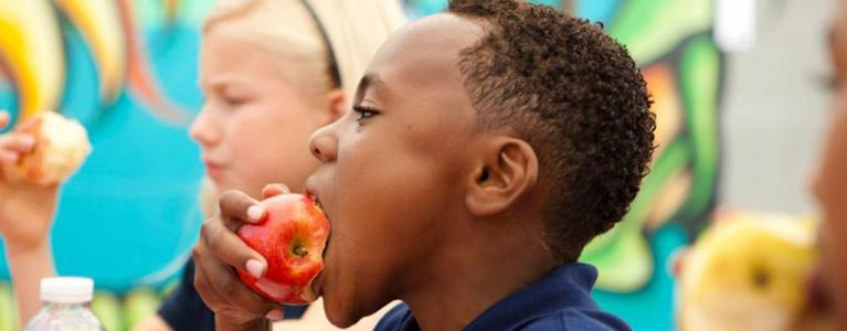 School boy eating apple