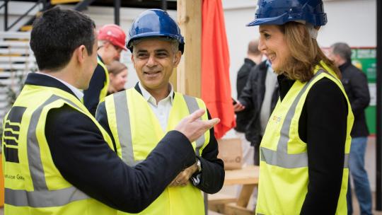Mayor in high vis speaking with apprentices at a building site