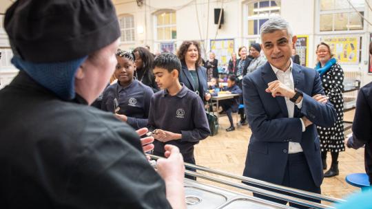 Mayor of London, Sadiq Khan, in a school canteen with canteen staff and students.