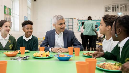 Mayor Sadiq Khan at a school table with four students eating lunch