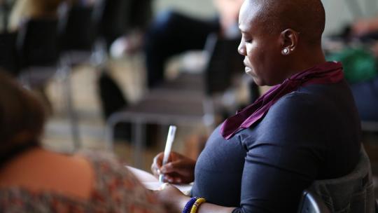 A woman taking notes at a Mayoral event