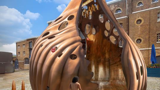 A picture of someone walking up a mock-up of The Wake, a bronze-coloured art piece by Khaleb Brooks