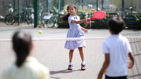 Children outside playing tennis