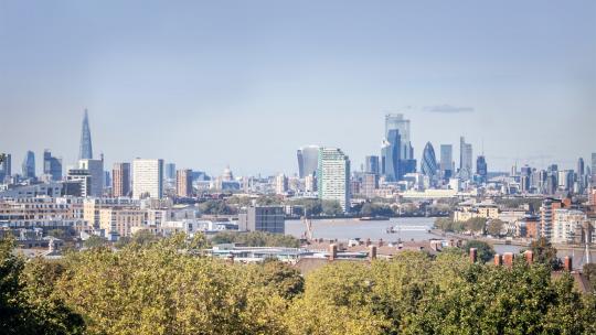 View of the City of London from behind some trees.
