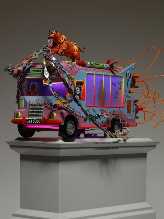 Blue and pink tone ice cream van with a tiger on top with jewels streaming out of its mouth on a light grey plinth, side angle view