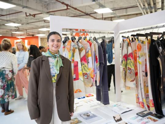 Woman with presentation table and rail of clothes