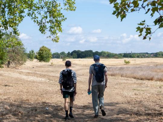 Two men walking in a dry field