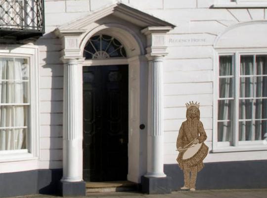 A photograph of a drawing of a child, with a crown and an African mask wearing a crown with a drum on a strap slung around their neck and is holding drum sticks, overlayed on the front of classical style, porticoed building.
