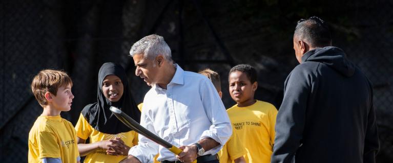 Sadiq Khan shaking hands with a child at Shine Street Cricket event