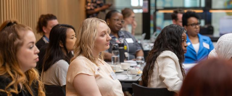 A group of people sitting down at tables during a workshop.