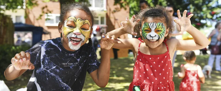 Two children wearing animal face painting