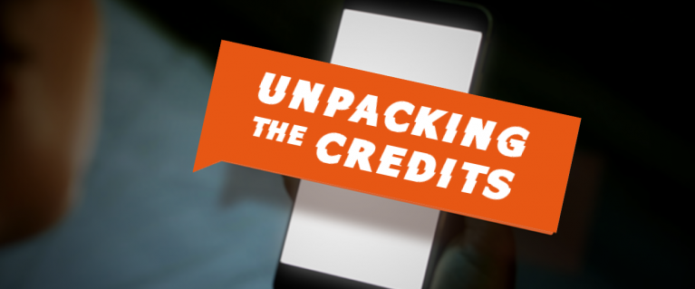 The phrase 'Unpacking The Credits' written on an orange banner extending out of a phone screen.