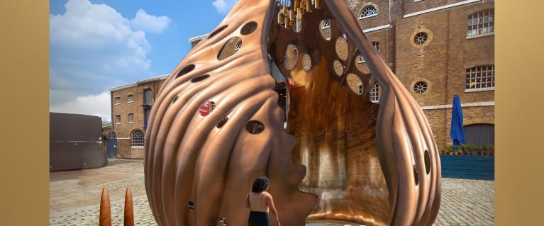 Computer-generated image with a traditional building in the background and a large, bronze colour sea shell, with a low ramp going into the centre, with a figure walking up the ramp. image with a traditional building in the background and a large, bronze colour sea shell, with a low ramp going into the centre, with a figure walking up the ramp.