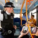 Police officer speaks with member of the public on a bus