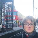Assembly Member, Caroline Russell stands next to an air quality monitor on Brixton Road.