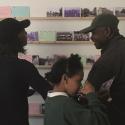 Three people looking at postcards at a community event