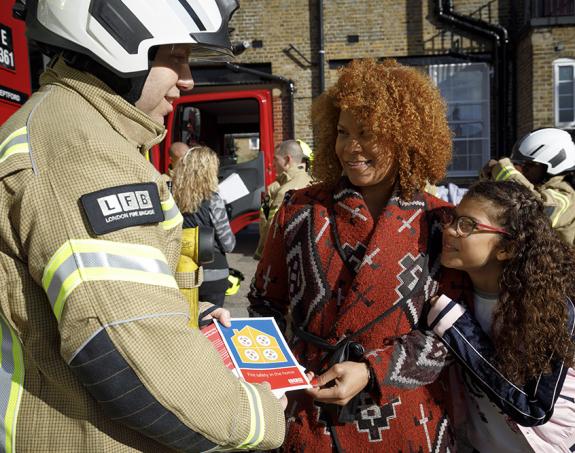 Fire fighter handing a leaflet to members of the public